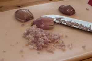 Red onions being finely chopped for the tomato soup base. 