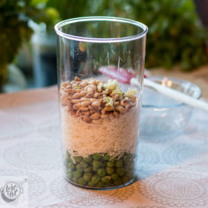 Container with thawed peas graded cheese, pine nuts and pressed garlic.