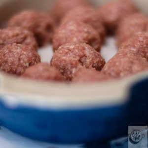 A dish of uncooked meatballs