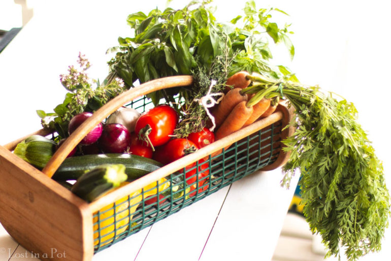 A basket full of fresh veggies and herbs from the herb'n' garden.