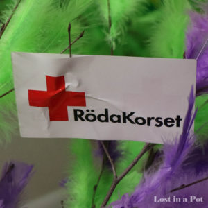 Feathers and the emblem of the Swedish Red Cross.