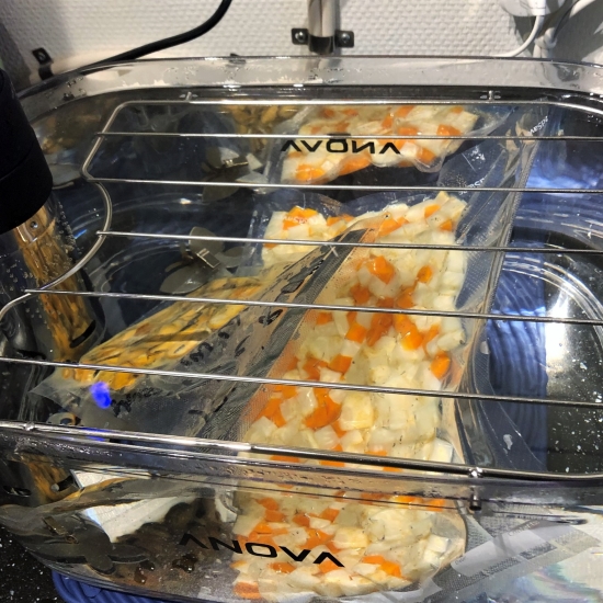 Veggies and mussels reheating in the sous vide. Veggies and mussels reheating in the sous vide.