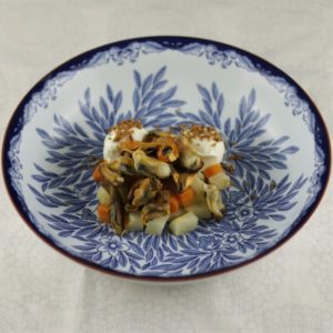 Placing the mussels on the carrots and celeriac in the bowl. Placing the mussels on the carrots and celeriac in the bowl.